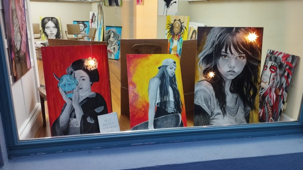 Künstlerische Ölgemälde, farbenfroh und schwarz-weiss, Portraits von Frauen in verscheidenen Stilrichtungen im Schaufenster bei Inskin Tattoo Radolfzell
